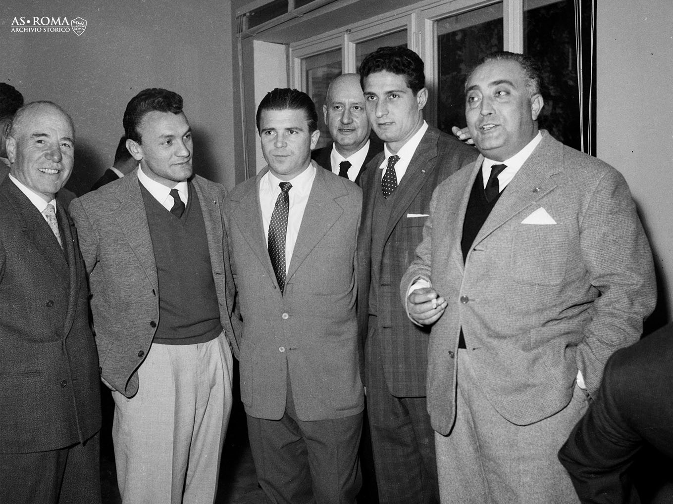 Giacomo Losi e Giosuè Stucchi posano per una foto ricordo con Ferenc Puskas, in occasione del ricevimento organizzato nella sede sociale giallorossa alla vigilia dell'amichevole tra le due squadre, Roma, Viale Tiziano, martedì 11 dicembre 1956.
